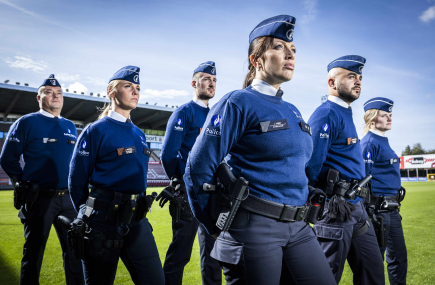 Een vrouwelijke en mannelijk inspecteur poserend rug aan rug